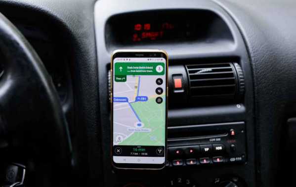 Telefoon in houder in auto met Google Maps aan