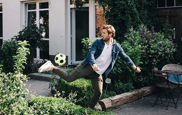 Man speelt voetbal in tuin
