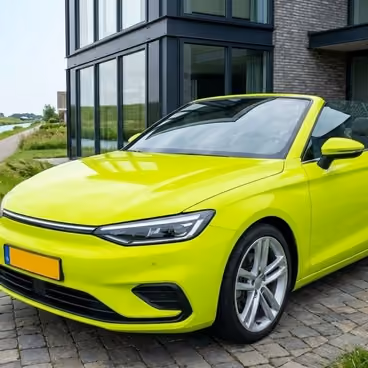Een knalgele cabrio staat voor een grote villa