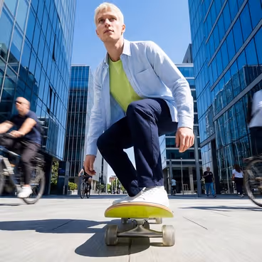 Een man rijdt op een skateboard door de stad