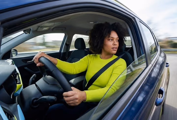 Een vrouw kijkt tijdens het rijden uit haar autoraam