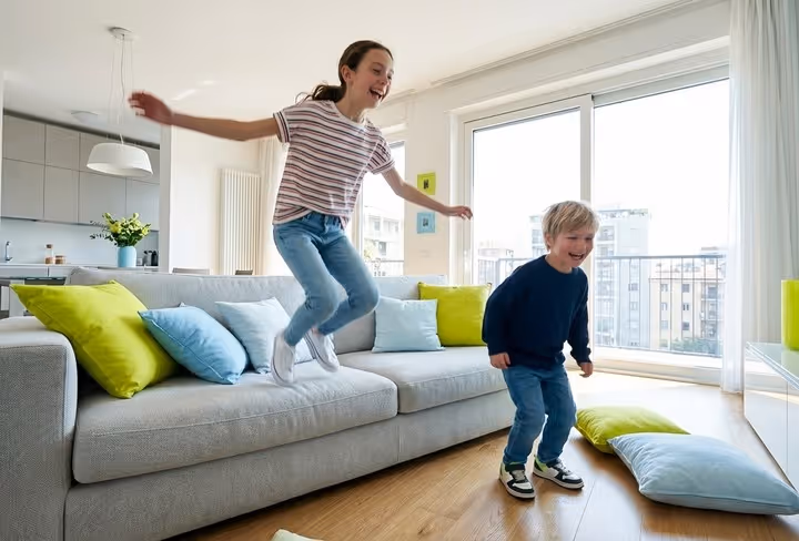 Twee kinderen springen vrolijk van een bank af