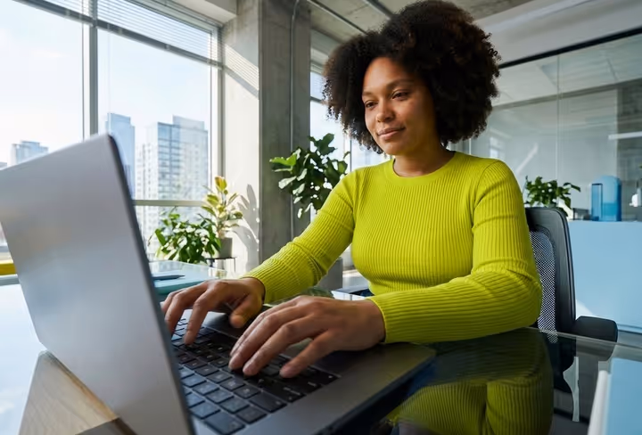 Een vrouw zit achter haar laptop