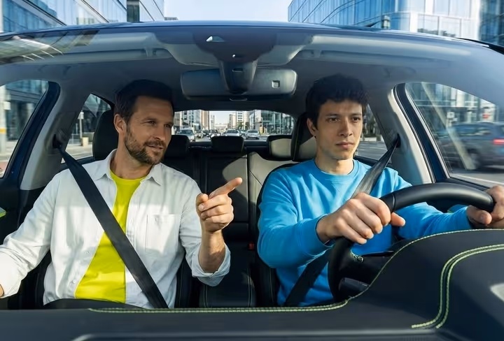 Een jongens zit met een rij-instructeur in de auto voor een rijles