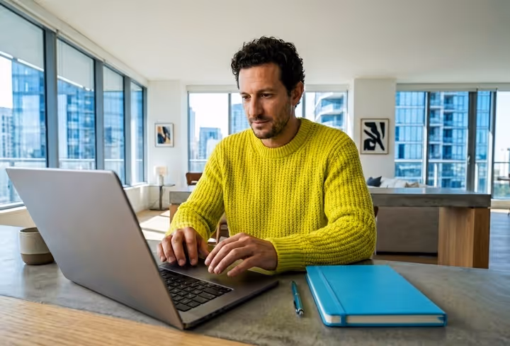 man zit thuis achter een laptop