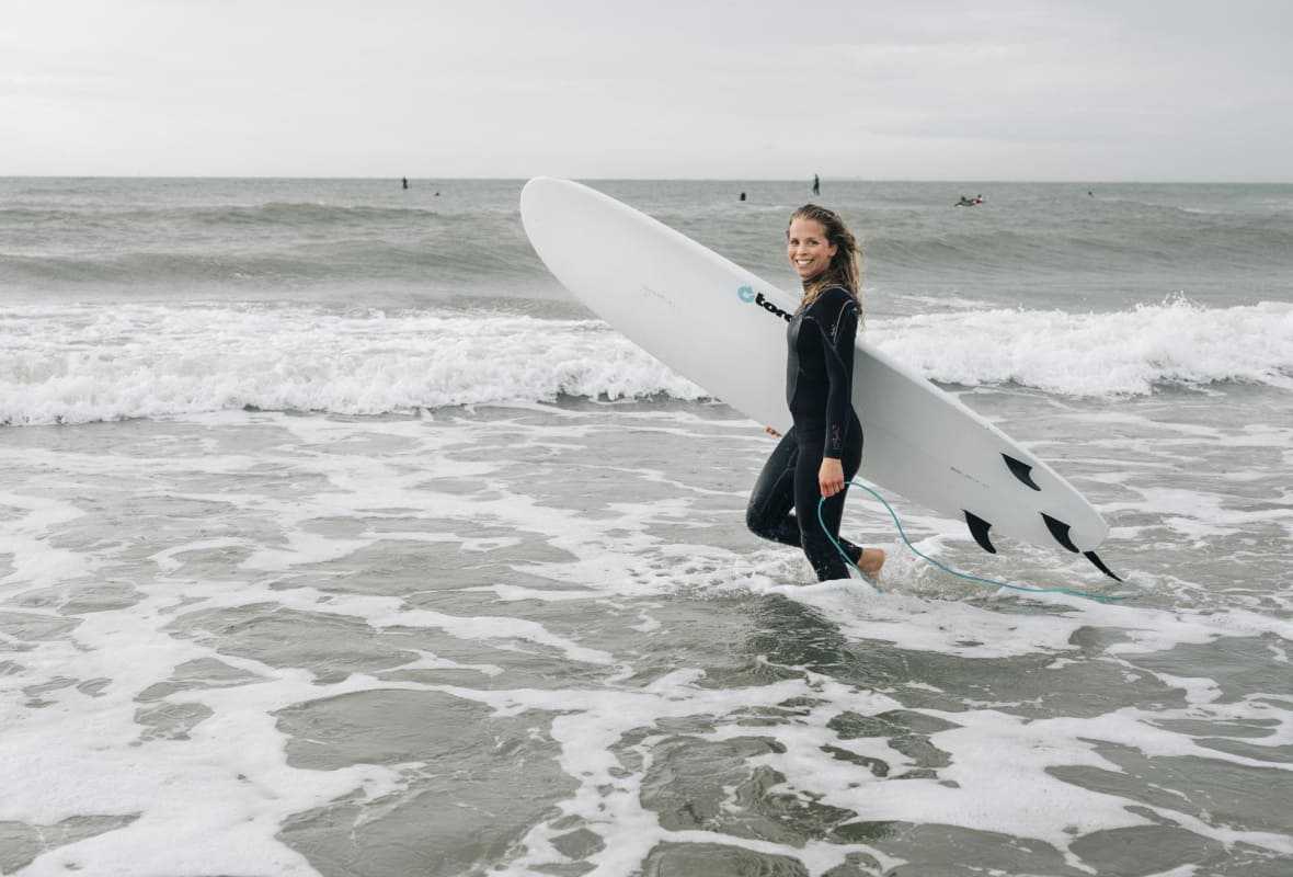 Vrouw in de zee met surfplank