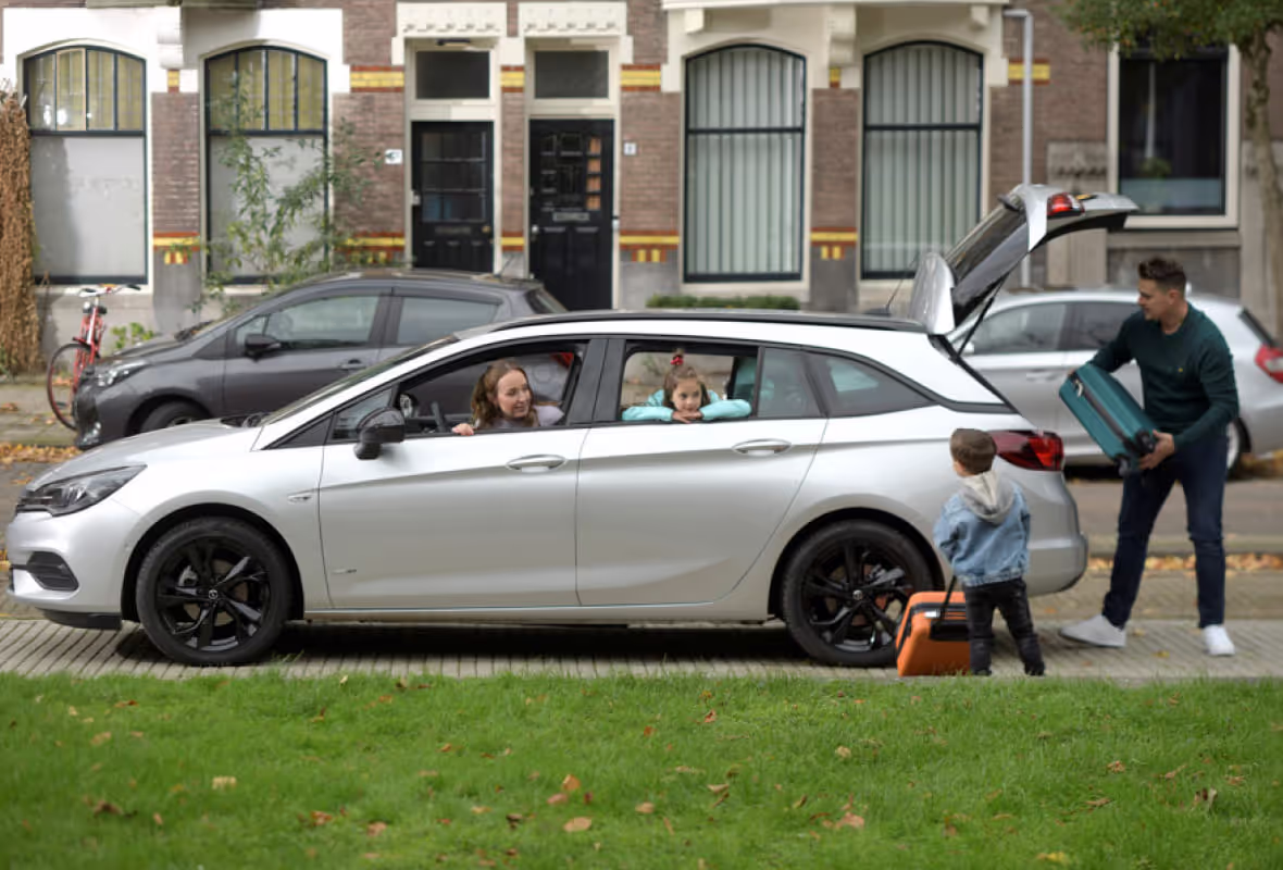 Kind met koffer bij auto 