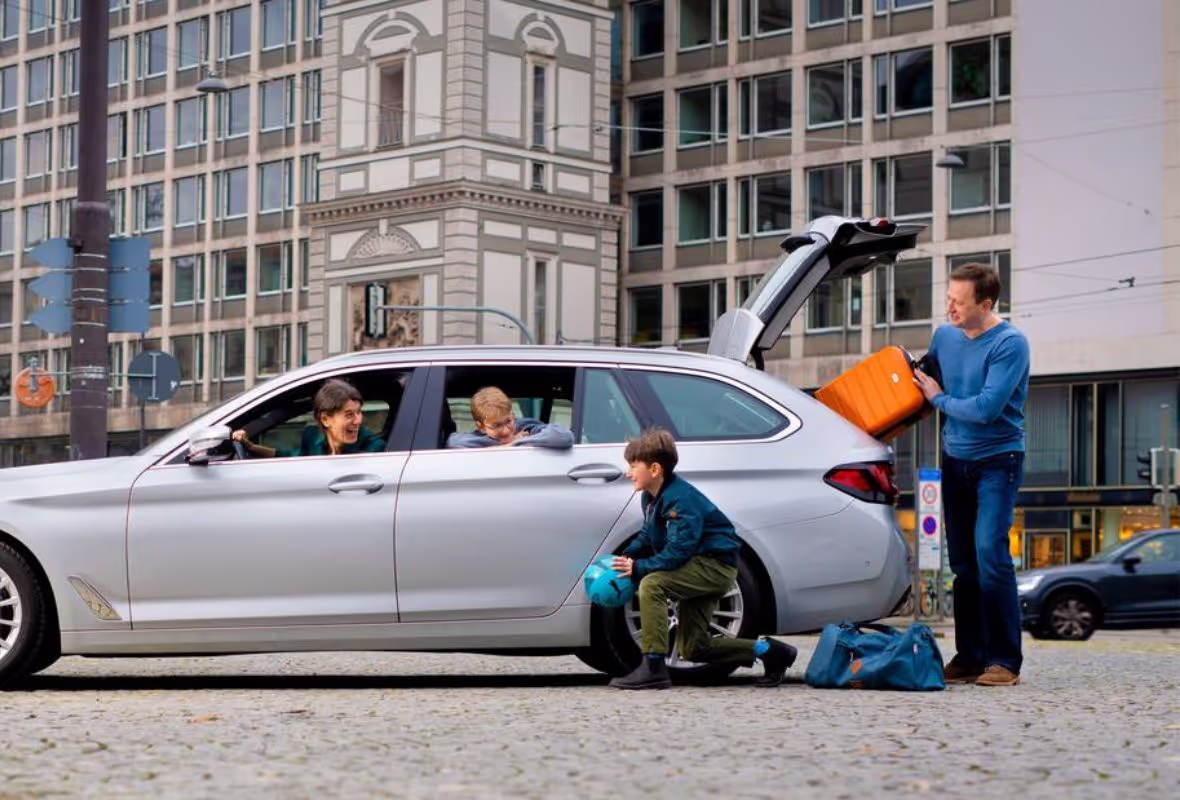 Familie met koffers bij auto