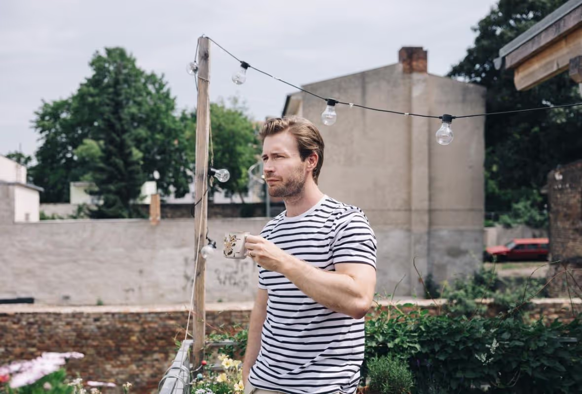 Man in tuin met koffie
