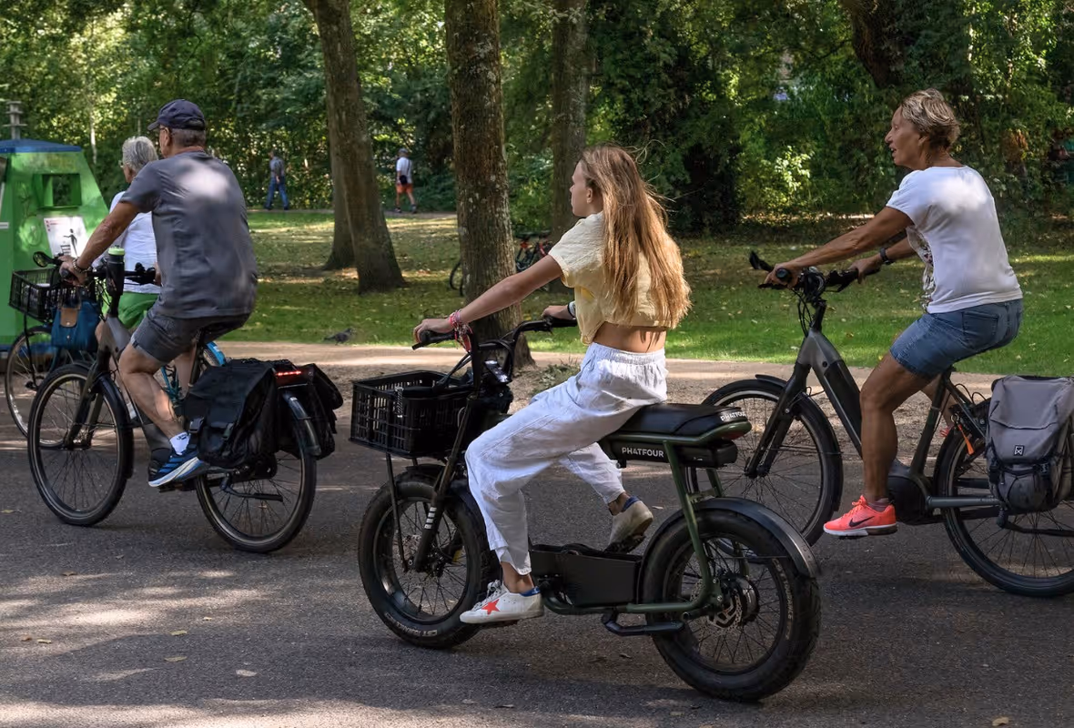 Een groepje jongeren fietst op fatbikes door het park