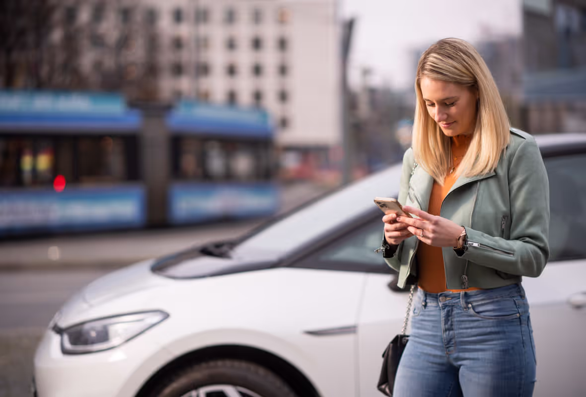 Vrouw met telefoon bij auto