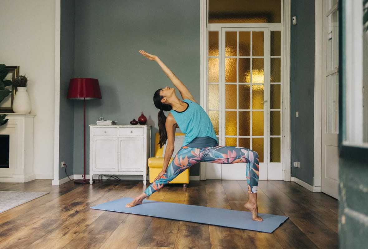 Vrouw doet aan yoga in huis 