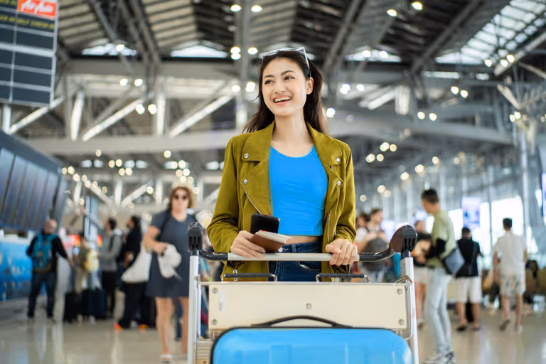 Vrouw op het vliegveld met koffers