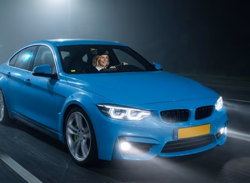 Een vrouw rijdt in het donker en in de mist met mistlampen aan