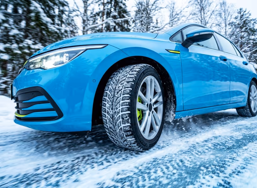 Een auto rijdt over een besneeuwde weg