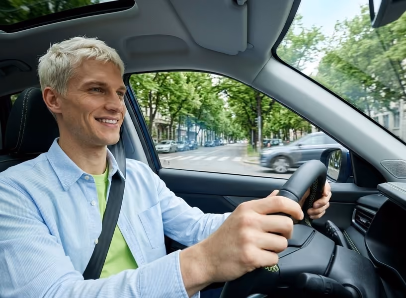 Een blonde man zit ontspannen in zijn auto
