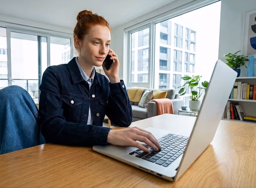Een vrouw zit thuis achter haar laptop