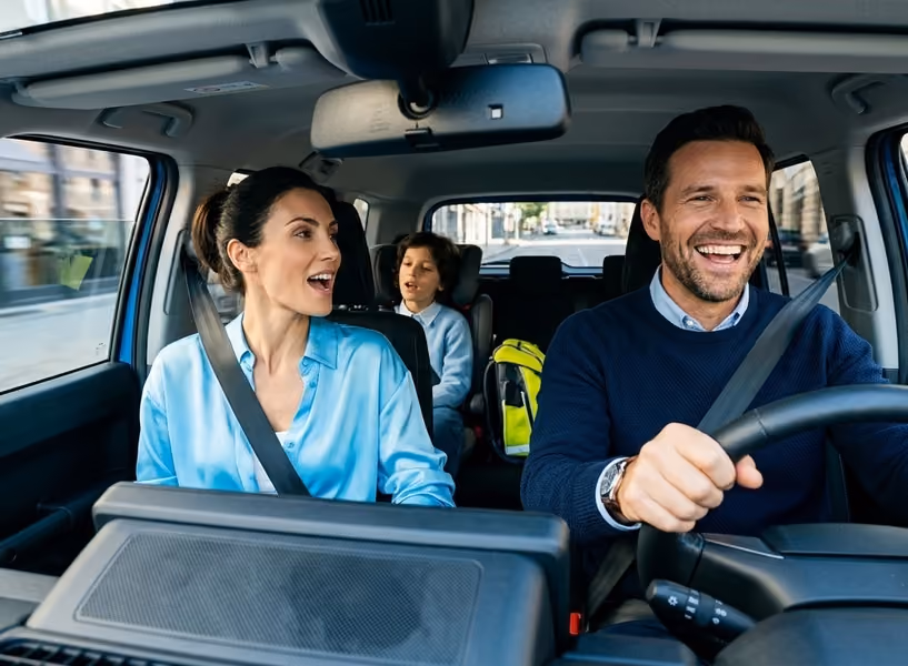 Een vrolijk gezin zit samen in de auto.