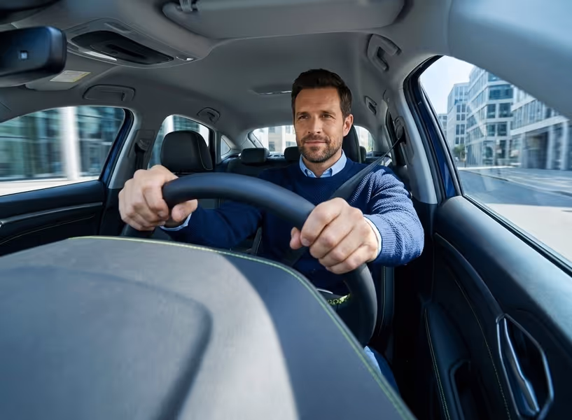 Een man rijdt in zijn auto