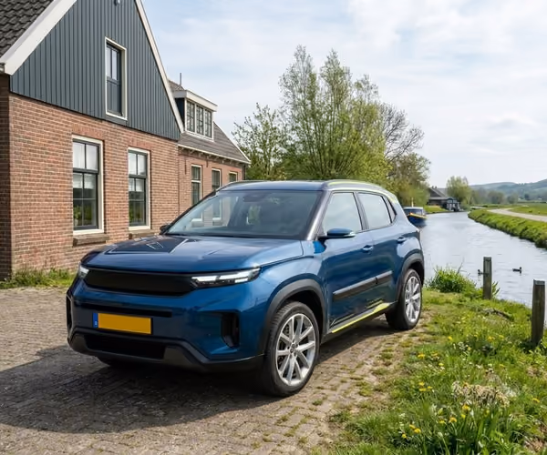 Een blauwe suv staat geparkeerd voor een groot huis in een landelijke omgeving