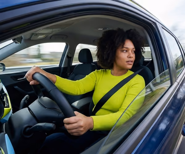vrouw kijkt over haar schouder in de auto