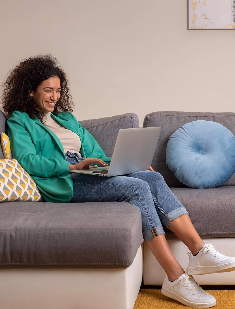 Vrouw zit op bank met laptop